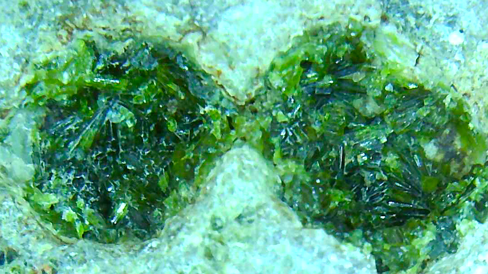 石の表面の穴にある緑の結晶